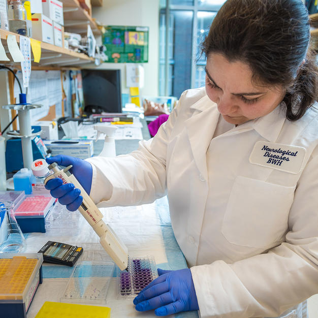 Female researcher pipetting in lab.