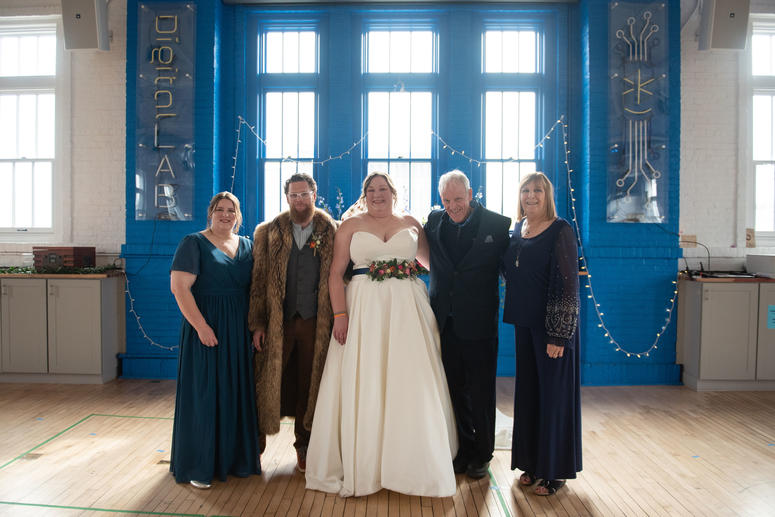 Kate and Matthew posing with family at her wedding