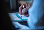 Close-up of someone writing with a pencil