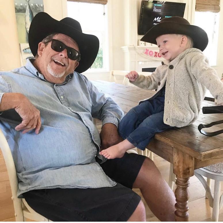 Teddy sits on a table next to his grandfather, Chip. 