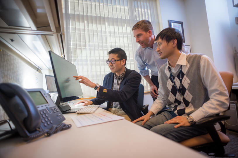 Three people looking at a computer screen