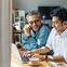 Two people smiling looking at laptop