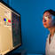 Female researcher in the lab wearing goggles while looking at a scan on the computer screen.